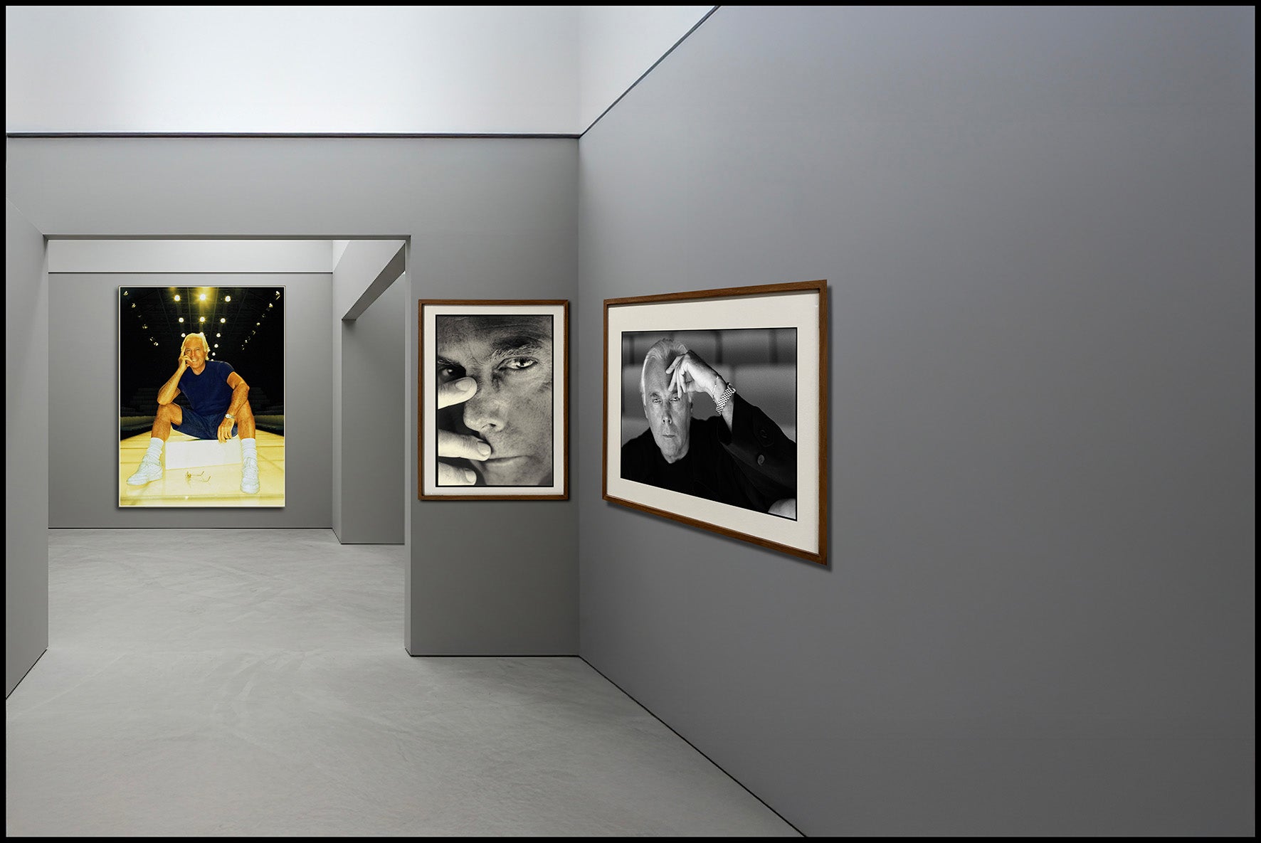 Gray gallery space with three different Armani portraits